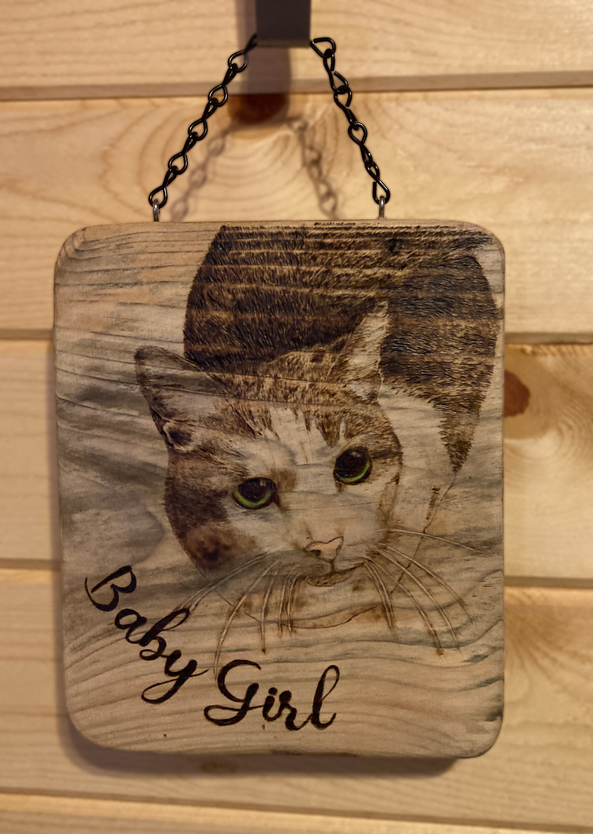 Wood burned image of a cat named Baby Girl.